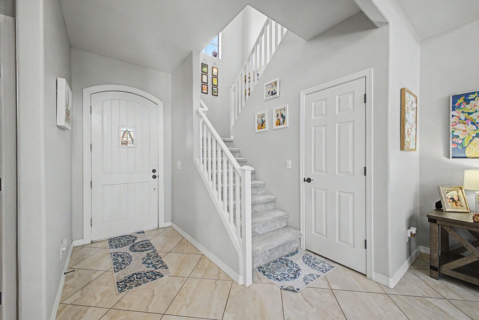 Foyer with front door, staircase and coat closet
