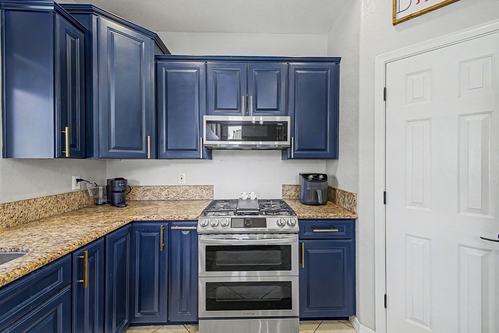 Navy kitchen cabinetry with a double-oven gas range