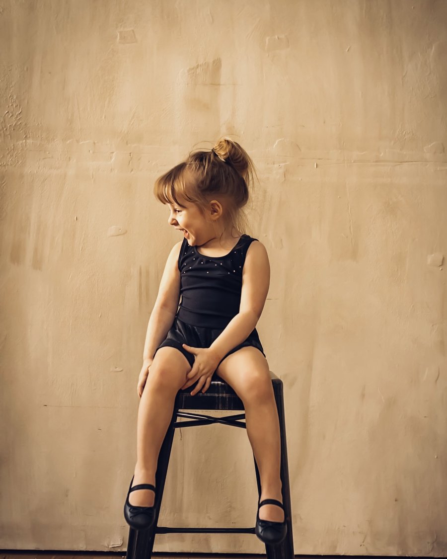 Megan&rsquo;s daughter sitting on a stool in a dance leotard