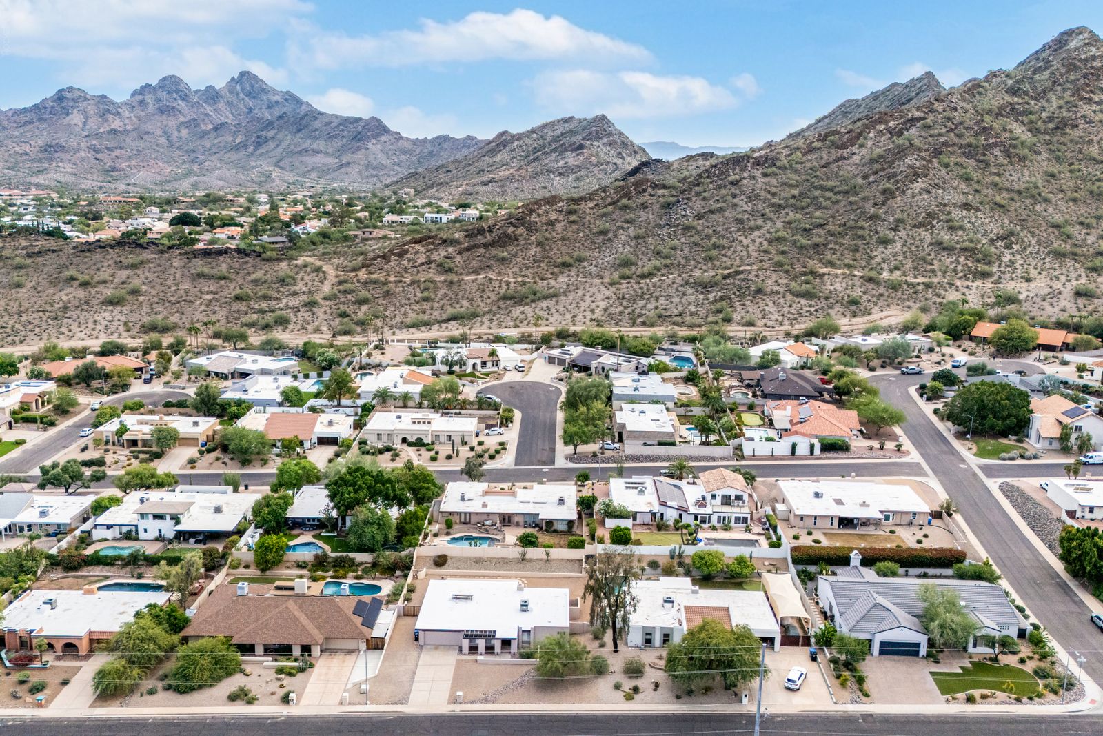 Aerial view of the home, the neighborhood and the mountain preserve trails behind it