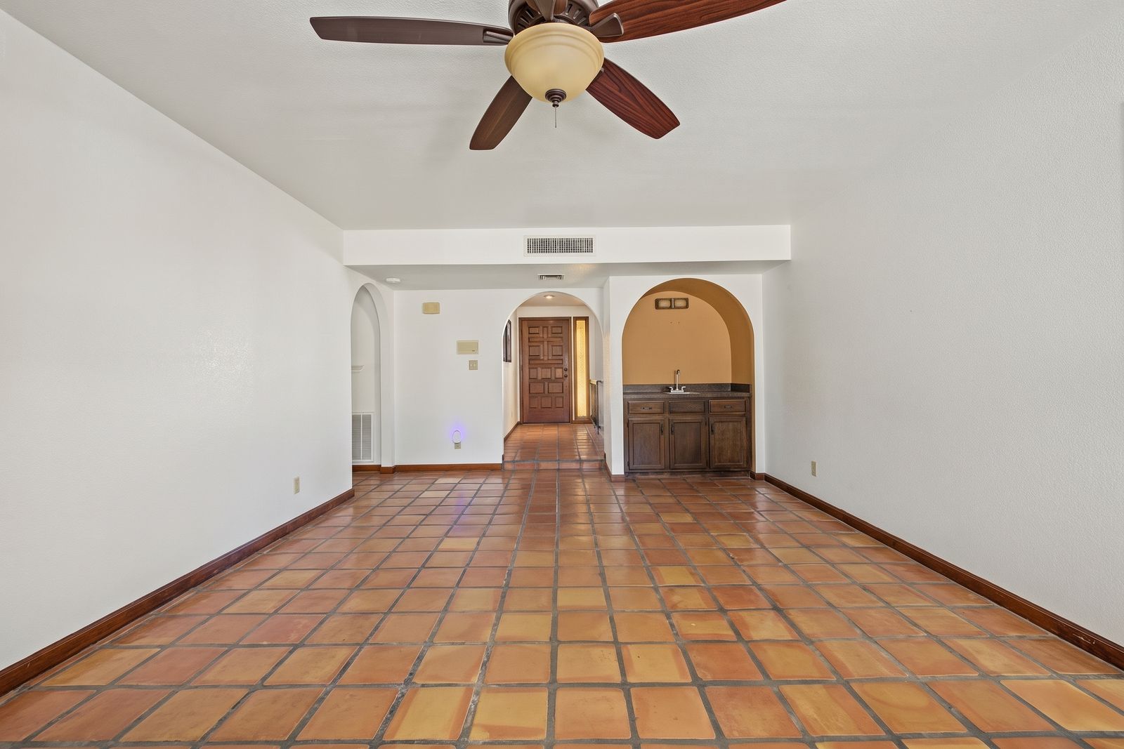 Family room with arched openings and a wet bar