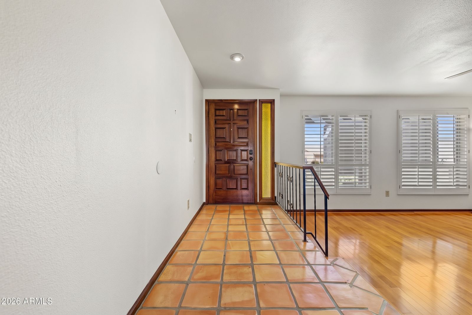 Entry foyer with Saltillo tile and a carved wood front door