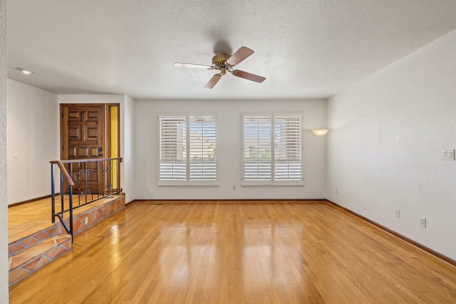 Living room with a wall sconce and plantation shutters