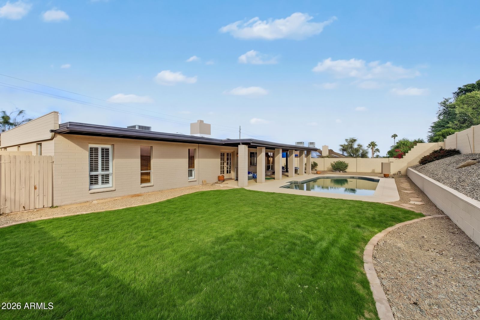 Digitally altered rendering of the backyard showing a lawn. The actual backyard is gravel desert landscaping, as shown in the other backyard photos.